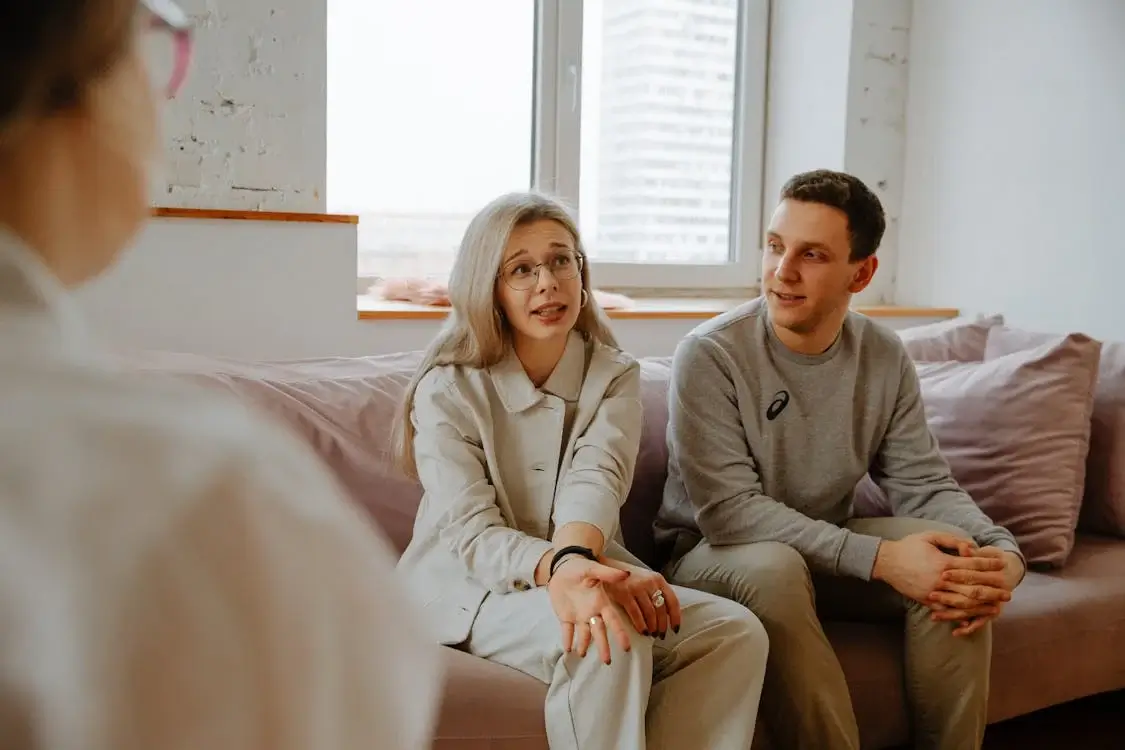 married couple on couch in conversation with therapist